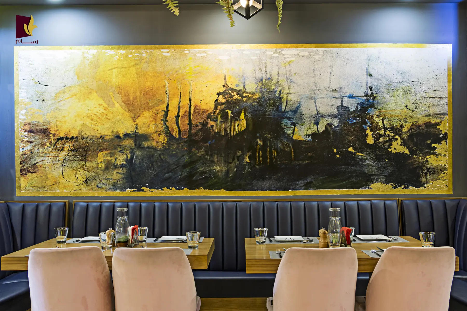 Restaurantwand mit goldenem Landschaftsmotiv über der Sitzbank