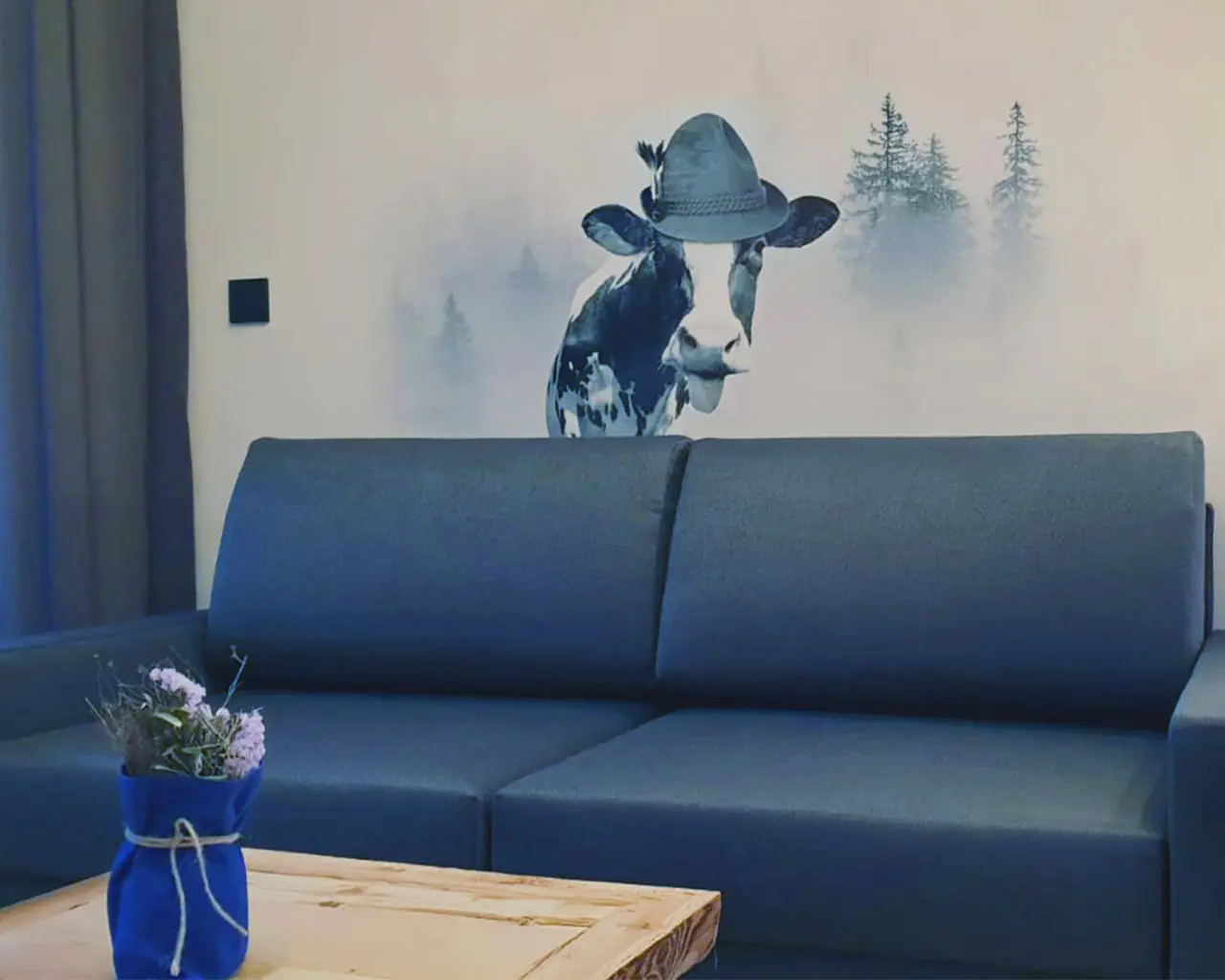 Hotellounge mit gedrucktem Motiv einer Kuh im Nebelwald