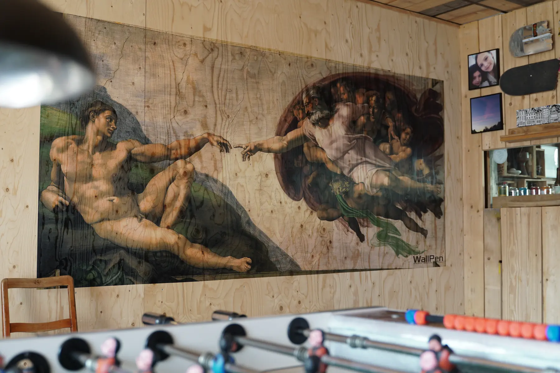 Michelangelo-Motiv auf einer Holzwand im Freizeitraum