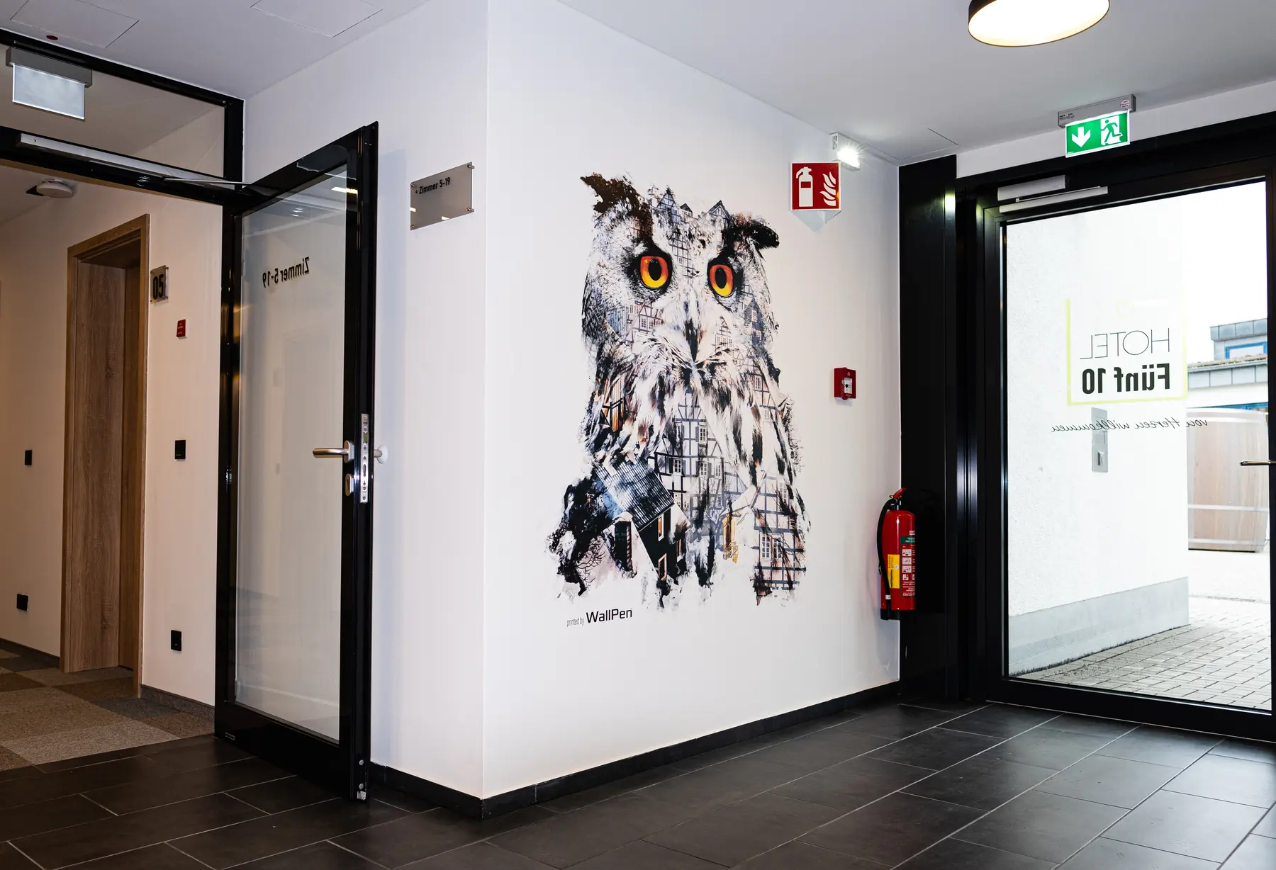 Bürogebäude-Flur mit großformatigem Eulenmotiv